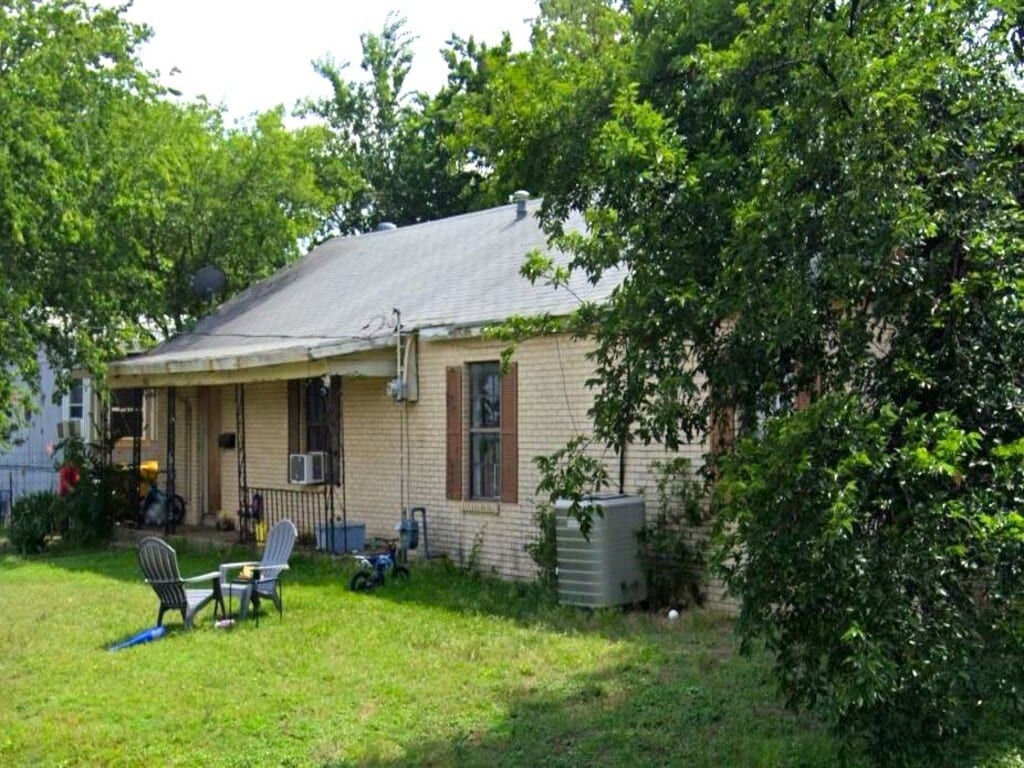 back of property with central air condition unit, a yard, and cooling unit