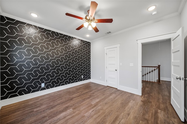 spare room featuring hardwood / wood-style flooring, crown molding, and tile walls