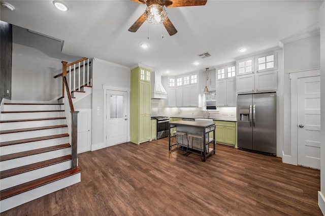 kitchen featuring dark wood-type flooring, green cabinetry, appliances with stainless steel finishes, a kitchen island, and ornamental molding