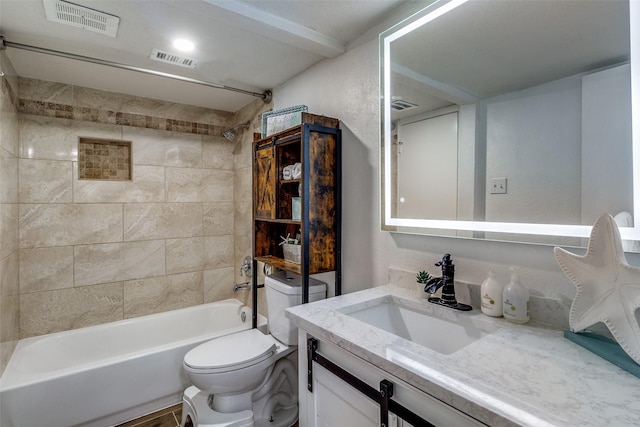 full bathroom featuring vanity, tiled shower / bath combo, and toilet