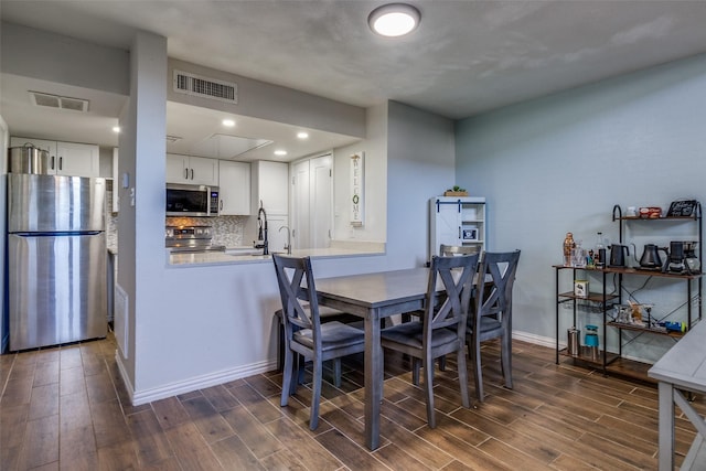 dining space featuring dark hardwood / wood-style flooring and sink