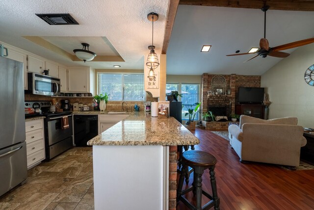 kitchen featuring sink, a breakfast bar area, appliances with stainless steel finishes, kitchen peninsula, and pendant lighting