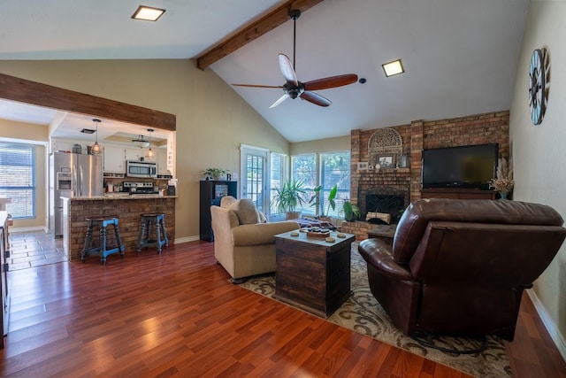 living room with ceiling fan, a fireplace, beam ceiling, and dark hardwood / wood-style flooring