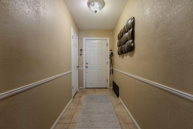 doorway with light tile patterned flooring