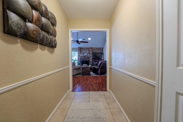 hallway featuring light tile patterned floors and a textured ceiling