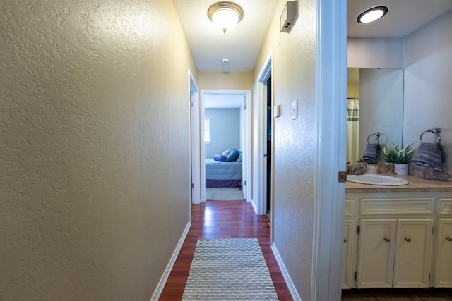 hallway featuring dark hardwood / wood-style flooring and sink