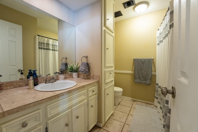 bathroom featuring vanity, tile patterned floors, and toilet