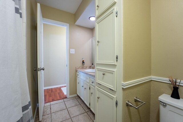 bathroom featuring tile patterned flooring, vanity, and toilet