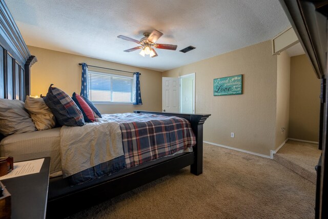 bedroom with ceiling fan, carpet, and a textured ceiling