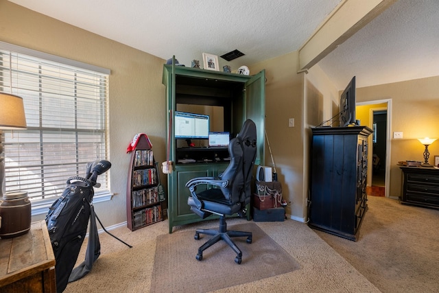 carpeted office space featuring beamed ceiling and a textured ceiling