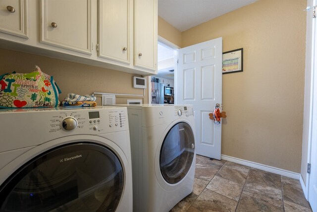 washroom featuring washer and clothes dryer and cabinets