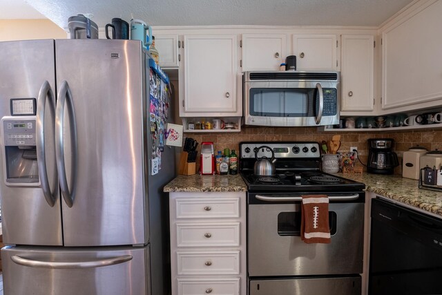 kitchen with stone counters, white cabinetry, appliances with stainless steel finishes, and backsplash