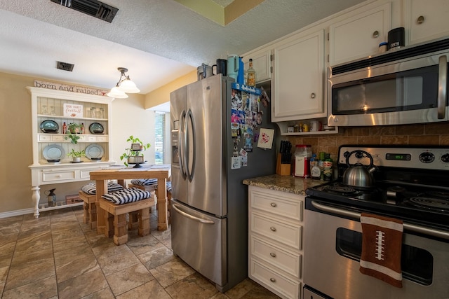 kitchen with white cabinetry, decorative light fixtures, a textured ceiling, stainless steel appliances, and backsplash