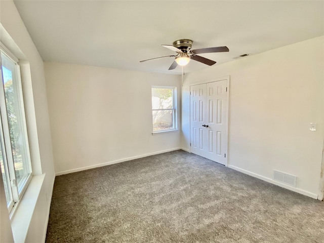 carpeted spare room with ceiling fan