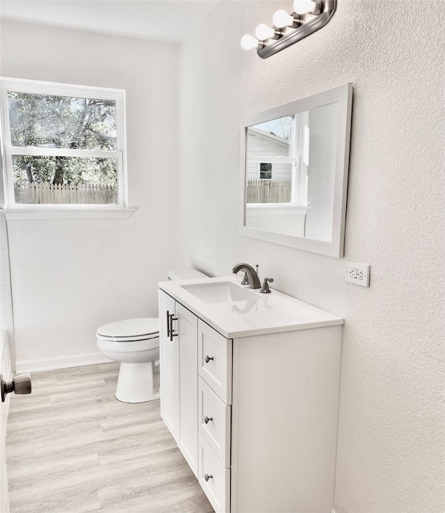 bathroom with vanity, toilet, and wood-type flooring