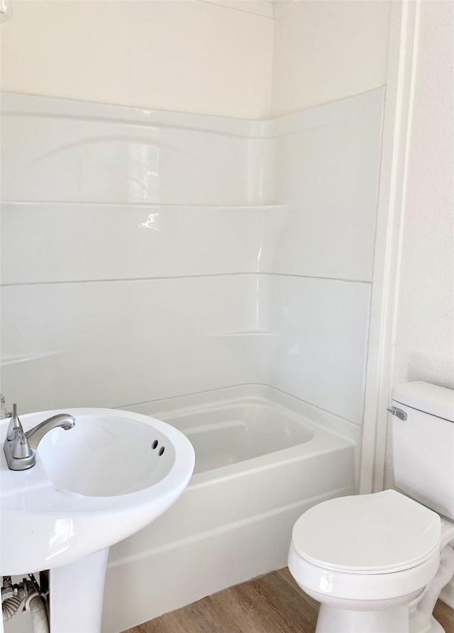 bathroom with  shower combination, toilet, and wood-type flooring