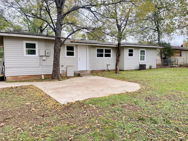 back of property with a yard and a patio