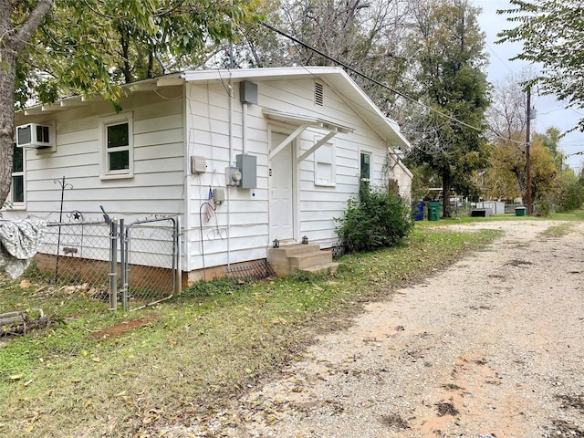 view of side of property with a wall mounted air conditioner