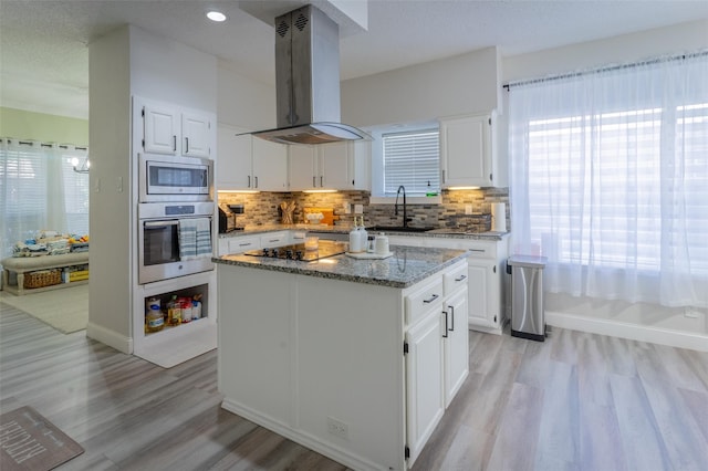 kitchen featuring island range hood, white cabinetry, and appliances with stainless steel finishes