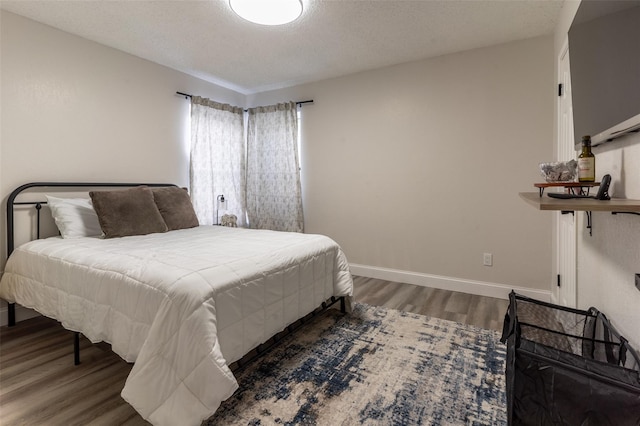 bedroom featuring hardwood / wood-style flooring and a textured ceiling