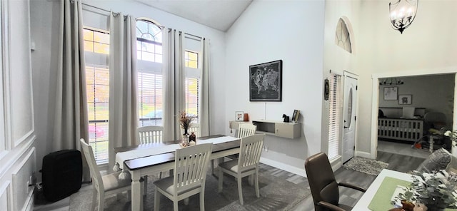 dining space featuring a notable chandelier, plenty of natural light, dark hardwood / wood-style flooring, and high vaulted ceiling