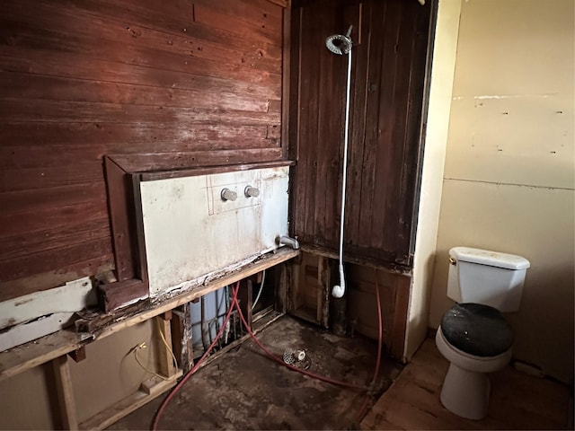 interior space featuring wooden walls and toilet