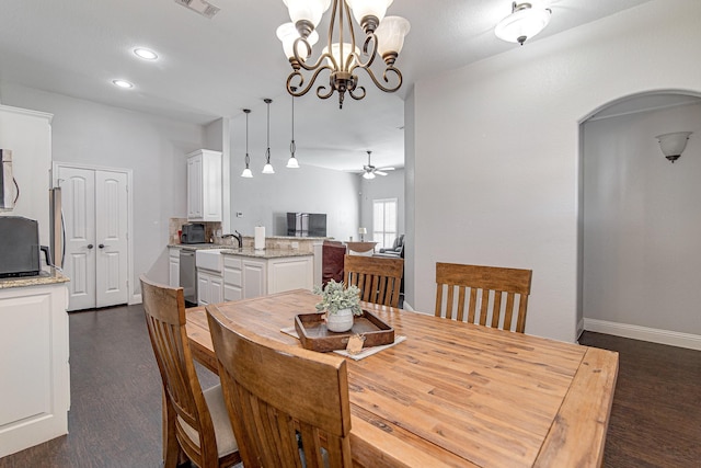 dining space with ceiling fan with notable chandelier and dark hardwood / wood-style floors