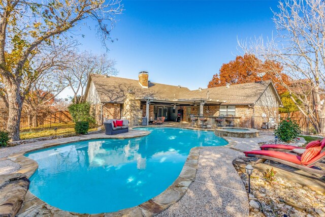 view of patio with an outdoor kitchen, exterior bar, ceiling fan, grilling area, and a fenced in pool