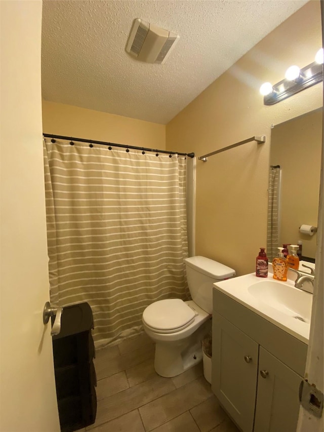 bathroom featuring walk in shower, vanity, a textured ceiling, and toilet