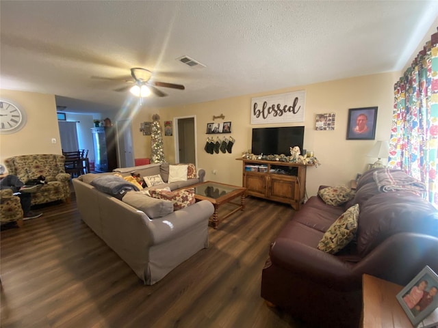 living room with ceiling fan, dark wood-type flooring, and a textured ceiling