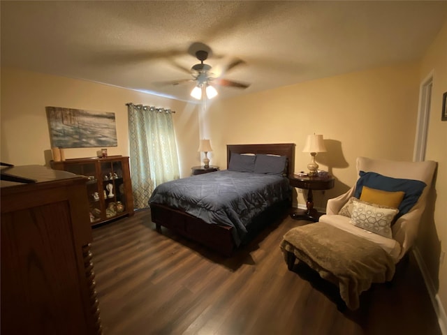 bedroom with ceiling fan, dark wood-type flooring, and a textured ceiling