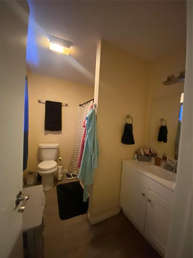 bathroom featuring hardwood / wood-style floors, vanity, and toilet