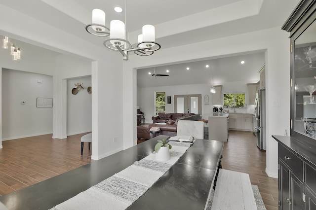 dining area featuring an inviting chandelier, dark wood-type flooring, french doors, and a healthy amount of sunlight