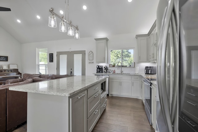 kitchen featuring french doors, sink, appliances with stainless steel finishes, a kitchen island, and backsplash