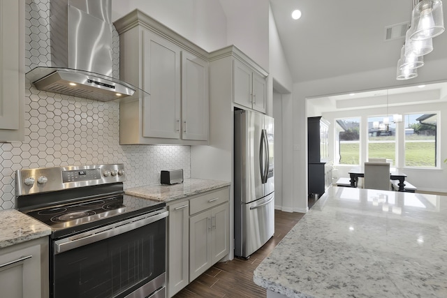 kitchen featuring stainless steel appliances, pendant lighting, backsplash, and wall chimney exhaust hood