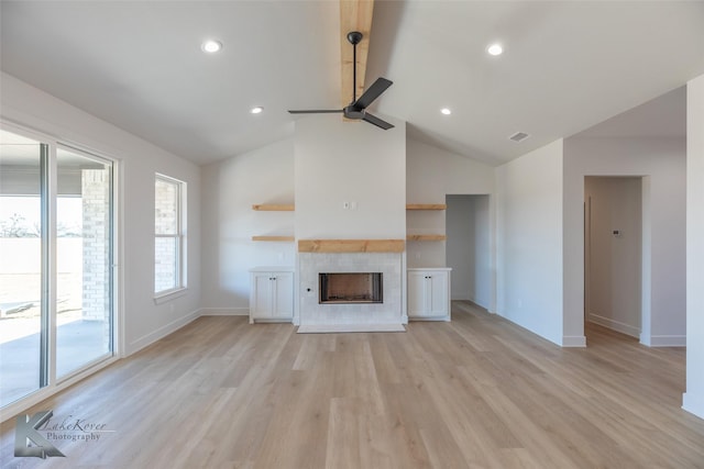 unfurnished living room featuring a tile fireplace, high vaulted ceiling, ceiling fan, and light hardwood / wood-style floors