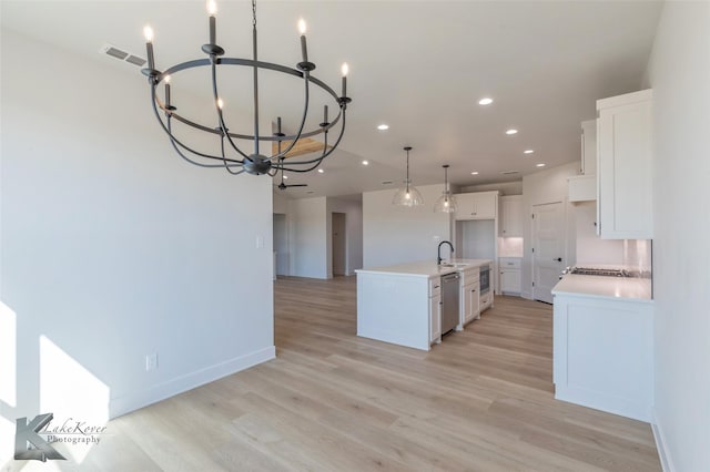 kitchen with sink, white cabinetry, a center island with sink, light hardwood / wood-style flooring, and stainless steel dishwasher