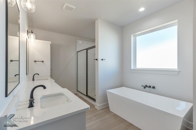 bathroom featuring shower with separate bathtub, hardwood / wood-style floors, and vanity