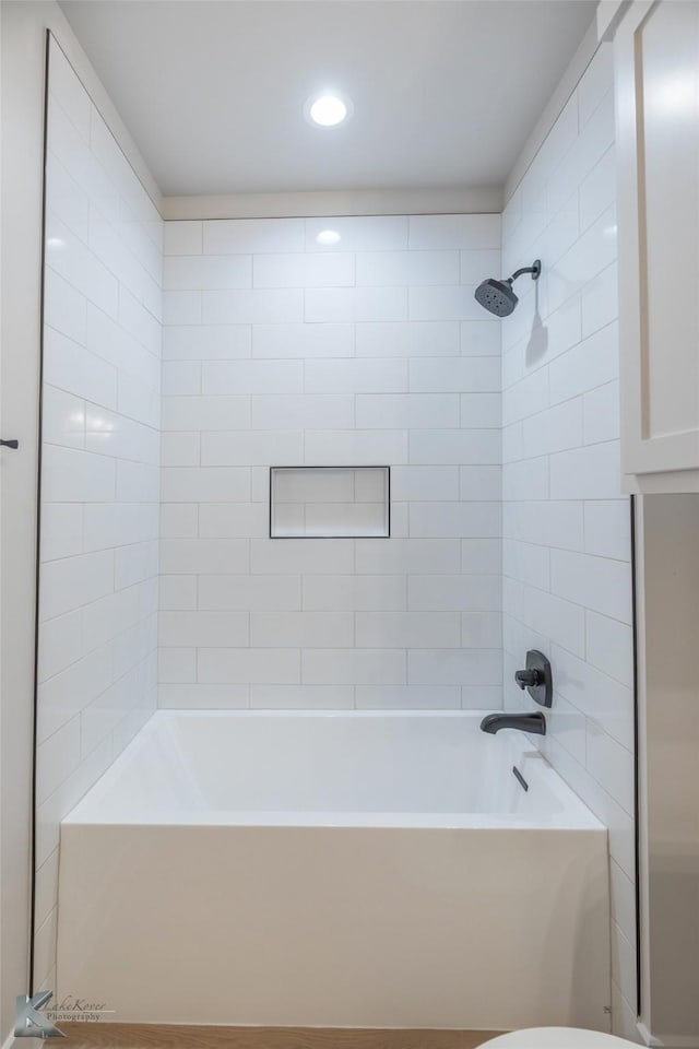 bathroom with tiled shower / bath and toilet