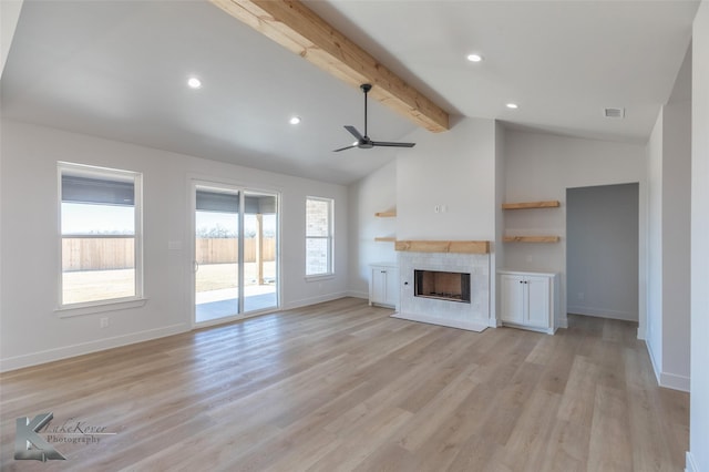 unfurnished living room featuring vaulted ceiling with beams, a fireplace, light hardwood / wood-style floors, and ceiling fan