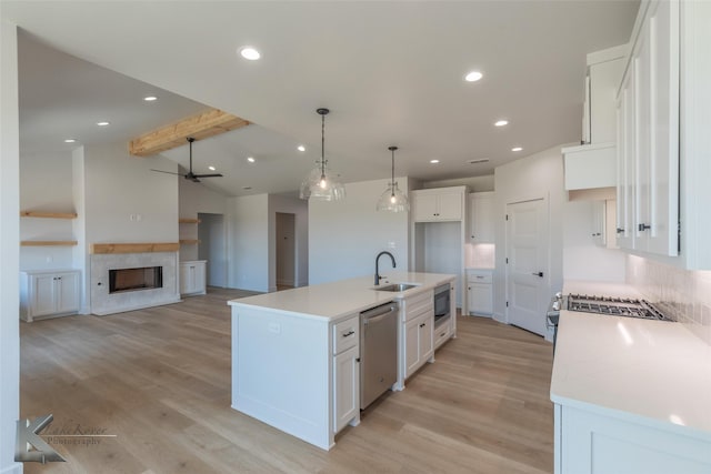 kitchen featuring white cabinetry, stainless steel dishwasher, an island with sink, and built in microwave