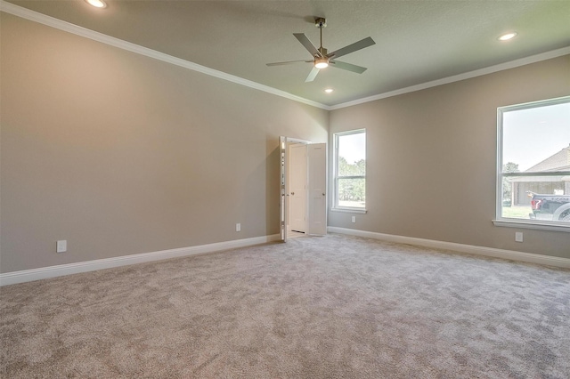 unfurnished room with ceiling fan, plenty of natural light, light colored carpet, and ornamental molding