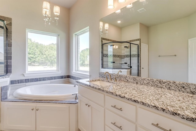 bathroom featuring a chandelier, vanity, and independent shower and bath