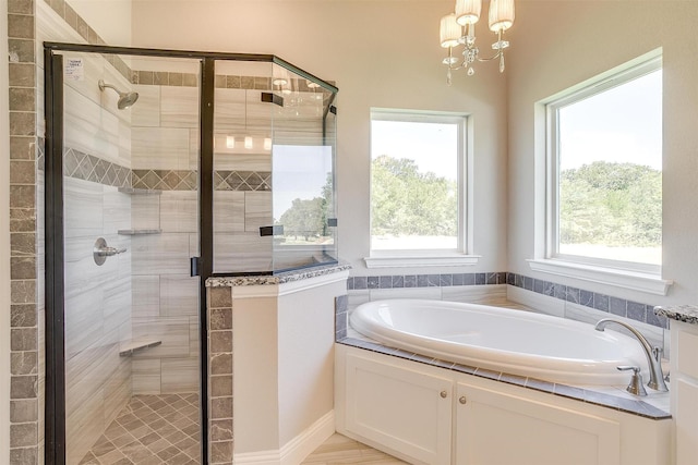 bathroom featuring separate shower and tub and a notable chandelier