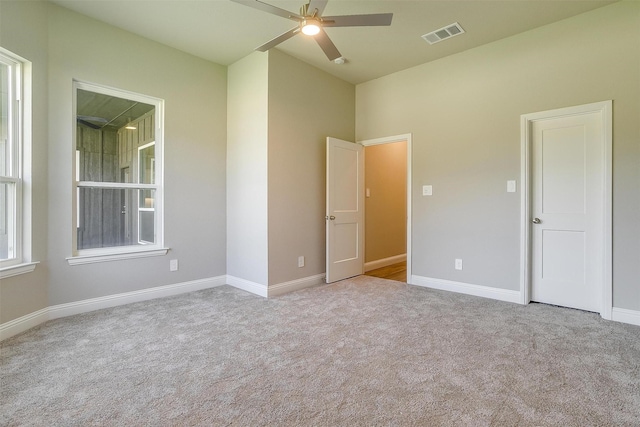 empty room with ceiling fan and light colored carpet