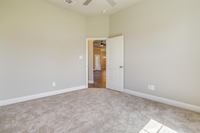 carpeted spare room with a towering ceiling