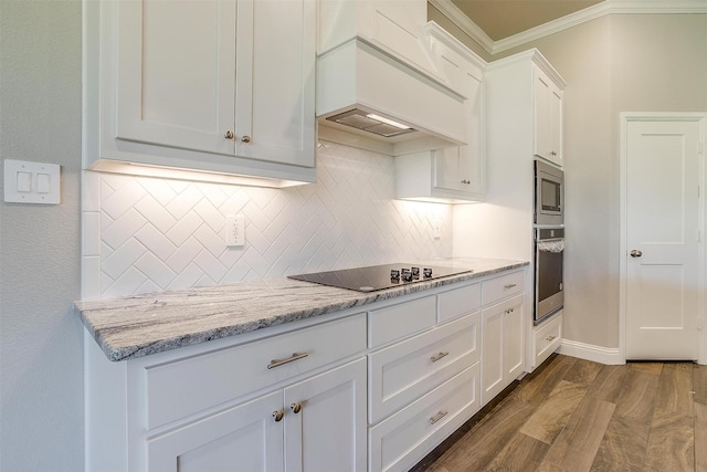 kitchen with appliances with stainless steel finishes, dark hardwood / wood-style flooring, premium range hood, light stone counters, and white cabinets