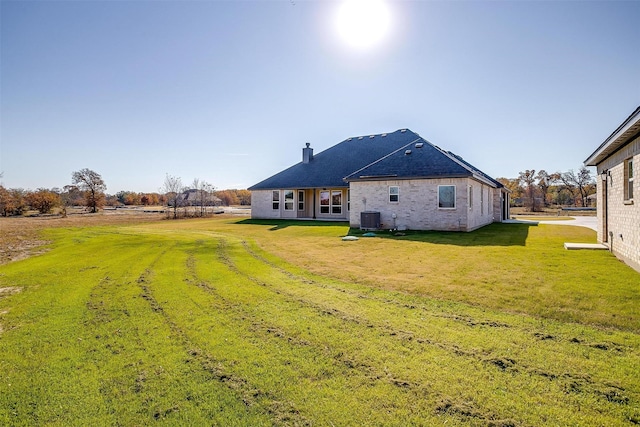 back of property with cooling unit and a yard