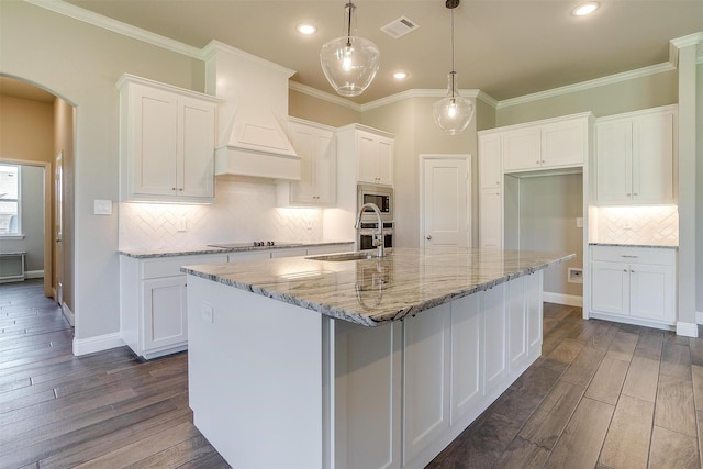 kitchen with white cabinets, sink, hanging light fixtures, and hardwood / wood-style floors