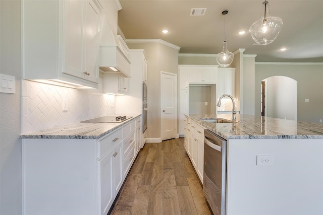 kitchen with appliances with stainless steel finishes, sink, a center island with sink, white cabinets, and hanging light fixtures